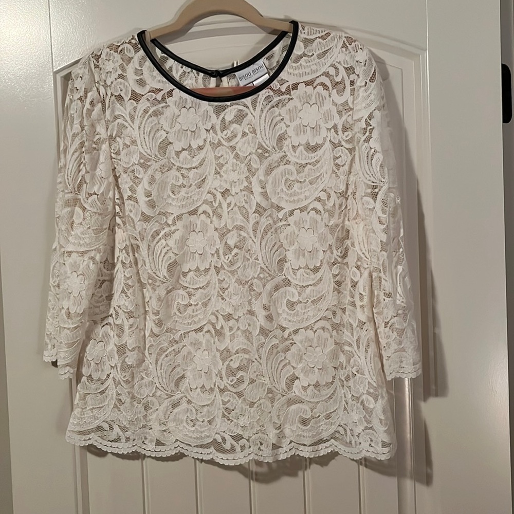 Beautiful ivory lace top with button closure on back and trimmed with leather